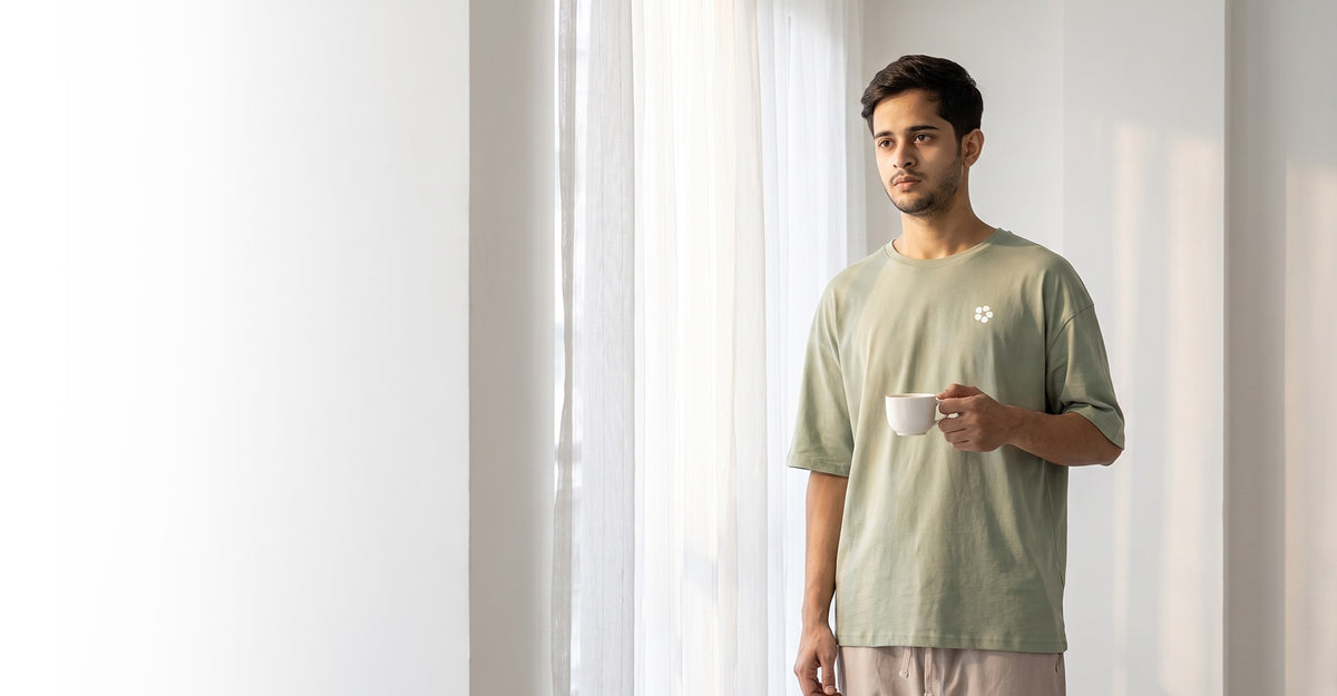 Man in a sage AeroCotton tee and linen trouser in a bright, calm room