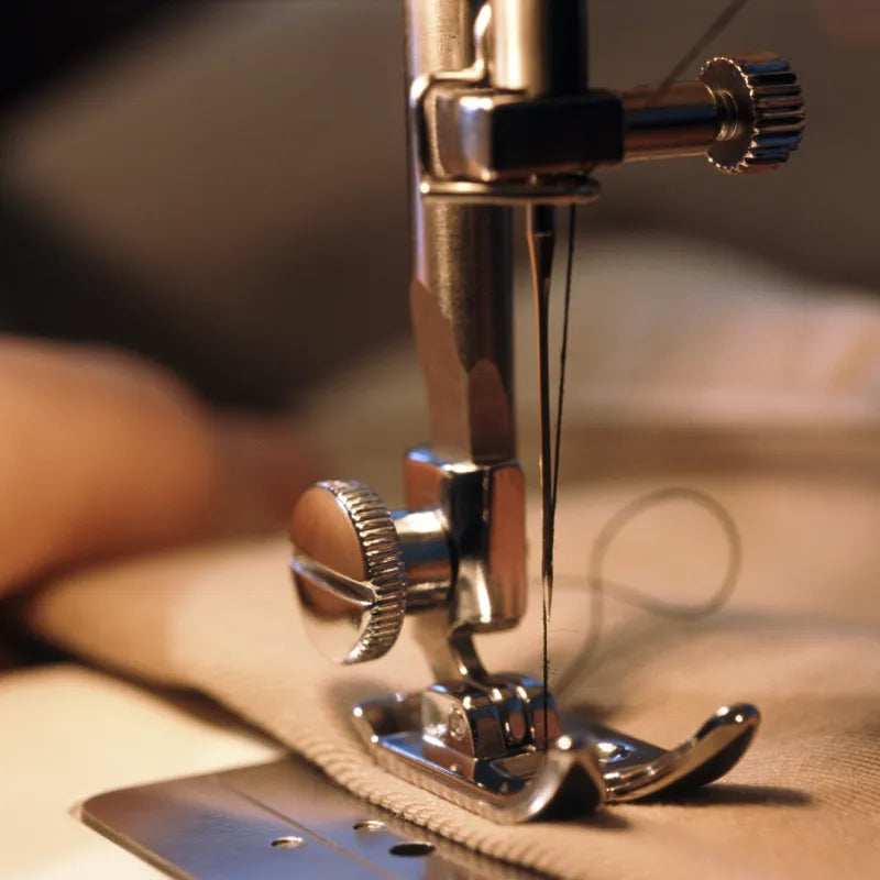 Sewing machine stitching a garment in our facility
