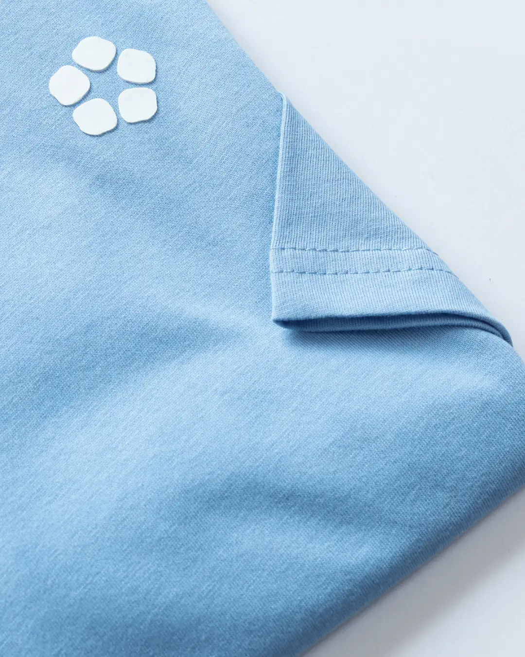 Close-up of a light blue AeroCotton tee with the COMFIQ logo
